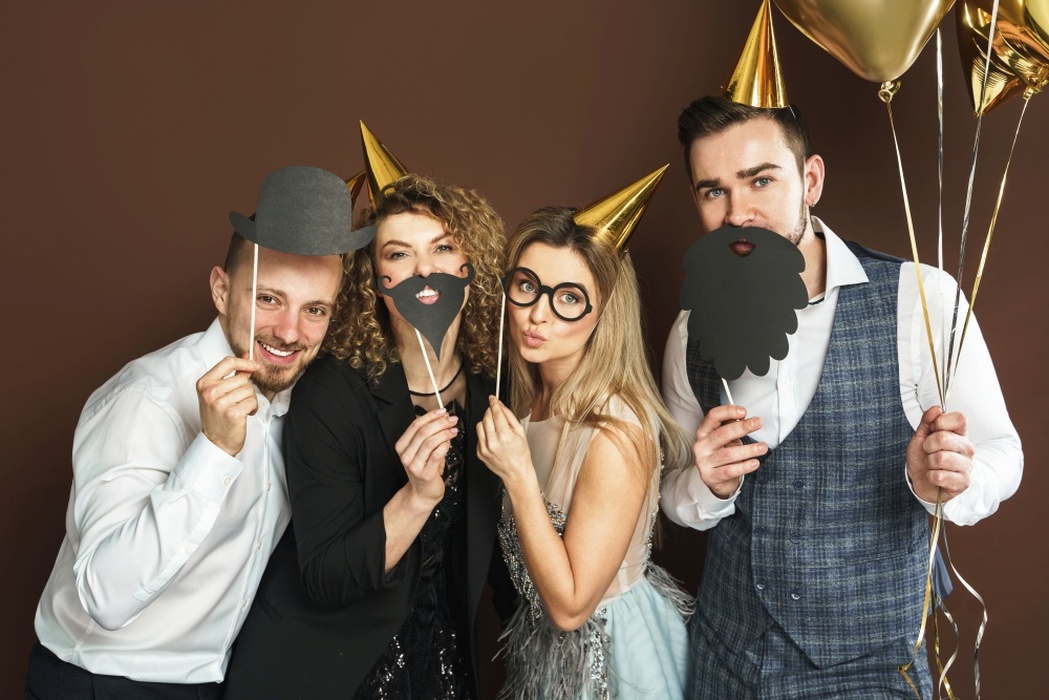 Bild aus einer Fotobox. Menschen mit Partyhüten, Ballon & Accessoires.